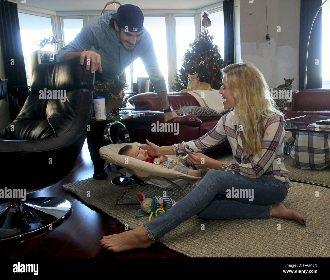 Tampa, Florida, USA. 19th Dec, 2015. DIRK SHADD | Times .Tampa Bay Lightning forward Brian Boyle with wife his wife Lauren, both 31, as she feeds their baby Declan, 7 months old, at their home in the Channelside neighborhood of Tampa on Saturday (12/19/15). Also present on the couch are their two pet Chihuahuas, Phoenix and Kingsly. The couple had Declan, their first child, in the middle of the Lightning playoff run last spring. © Dirk Shadd/Tampa Bay Times/ZUMA Wire/Alamy Live News Stock Photo