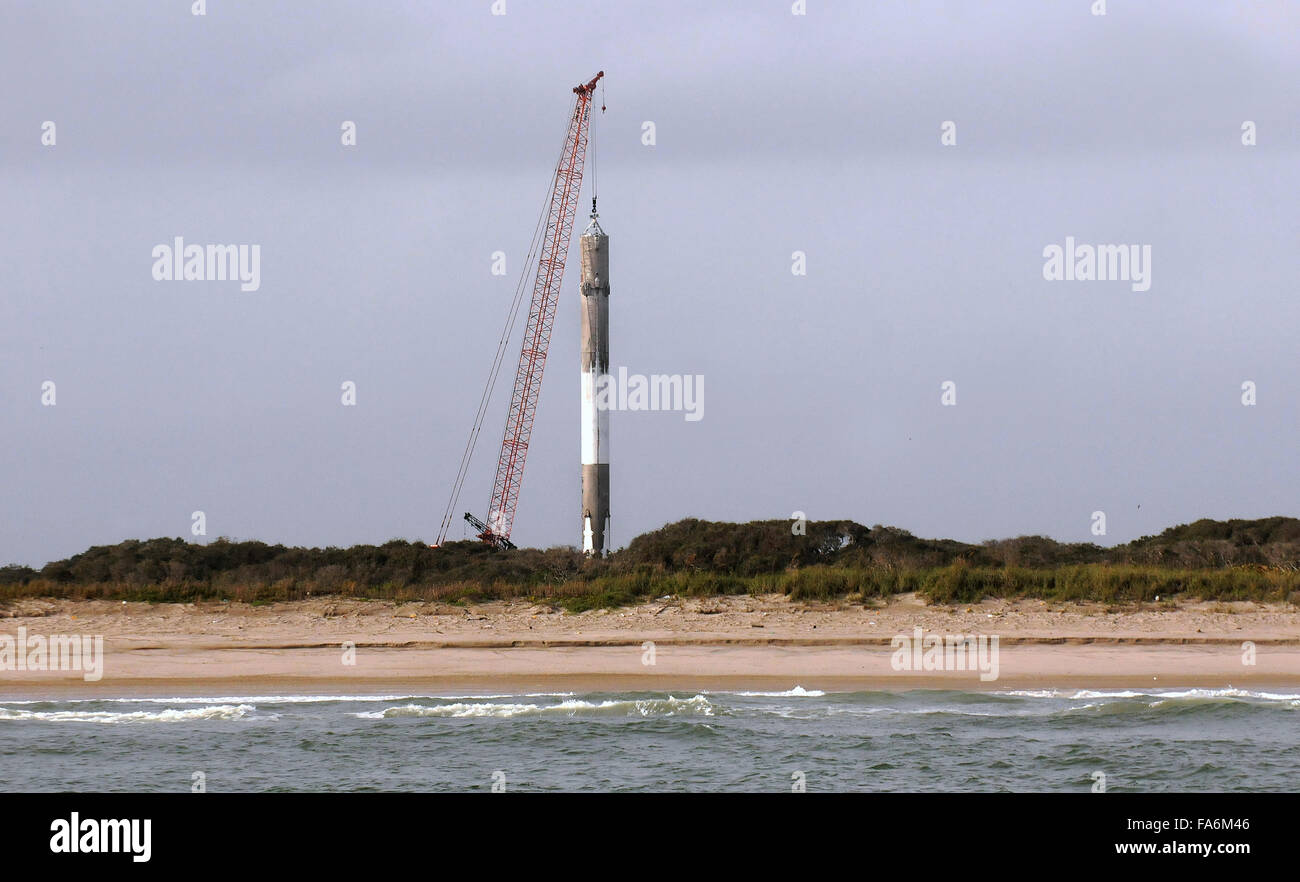 Cape Canaveral, Florida, USA. 22nd December, 2015. A crane is seen lifting the first stage of a SpaceX Falcon 9 rocket the morning after it launched 11 ORBCOMM communications satellites into orbit before successfully landing back at Cape Canaveral Air Force Station about ten minutes later on December 21, 2015. This is the first time that SpaceX has landed one of its rockets on land. The historic accomplishment marks a significant step in the technology of reusable rockets. Credit:  Paul Hennessy/Alamy Live News Stock Photo