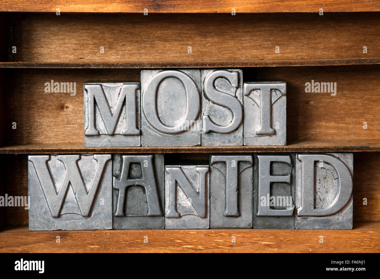 most wanted phrase made from metallic letterpress type on wooden tray Stock Photo