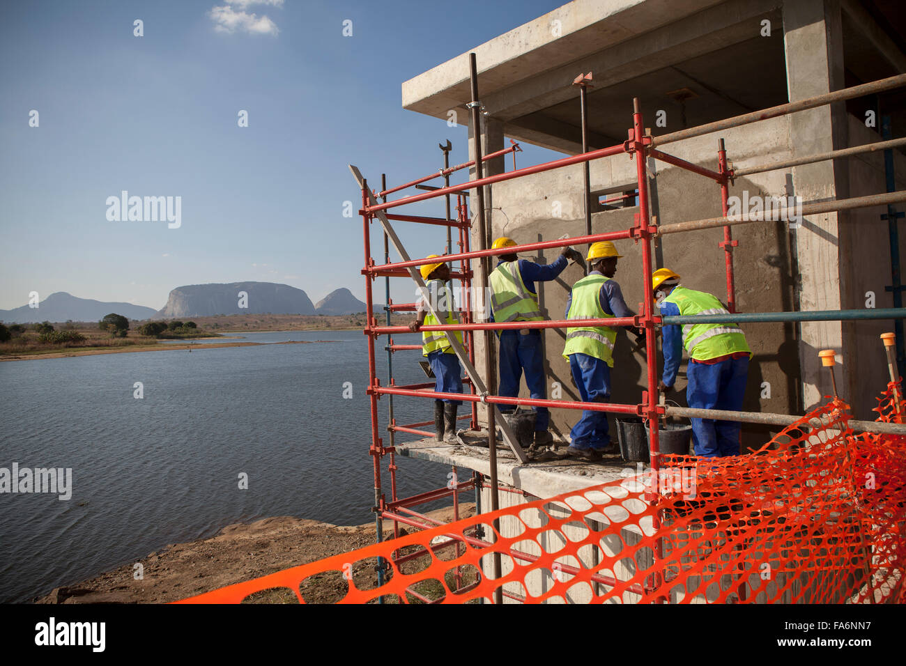 Workers construct a new water pumphouse along the Manapo Dam in Nampula, Mozambique. Stock Photo