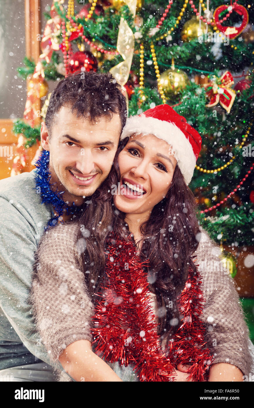 Christmas couple happily smiling enjoying holidays and snow , Happy couple celebrating New Year while snowing Stock Photo