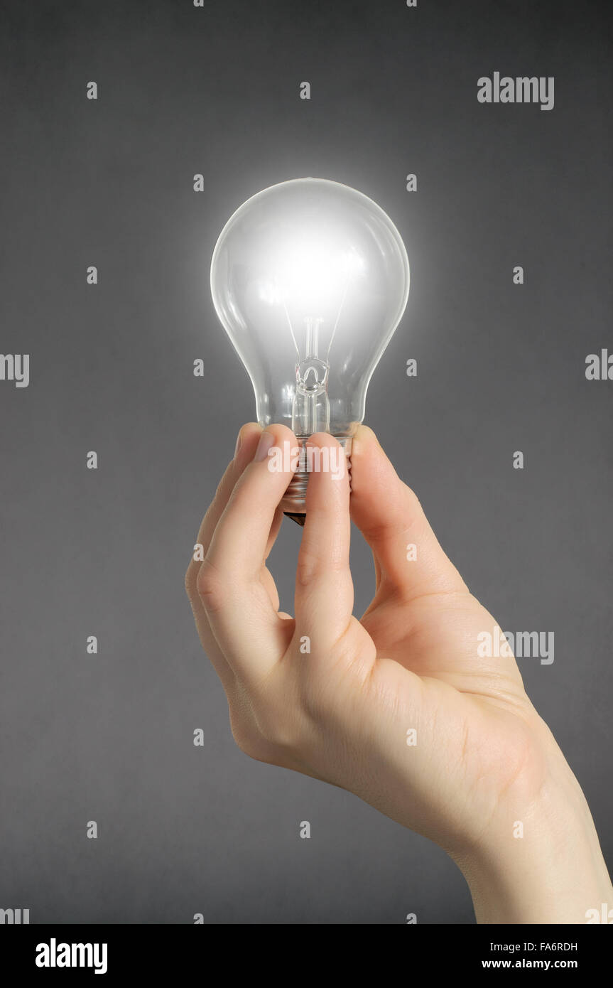 Hand holding a glowing light bulb Stock Photo - Alamy