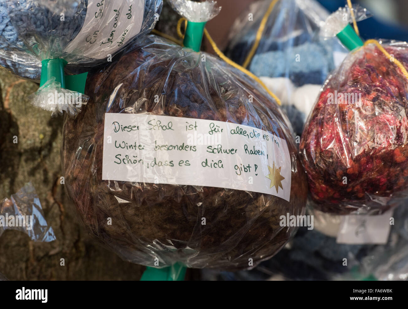 Offenburg, Germany. 22nd Dec, 2015. Packages of knitwear hang from the 'Warmnachtsbaum' (lit. warm night tree) in the centre of Offenburg, Germany, 22 December 2015. Four people from Freiburg have been using this and other campaigns to raise awareness of homelessness for about a year now. They have founded the 'be japy' association, and hope that their small gestures will inspire others to do something good. PHOTO: PATRICK SEEGER/DPA/Alamy Live News Stock Photo