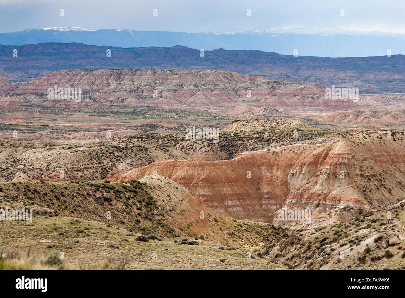 The Absaroka Mountains rise behind the badlands of the Bighorn Basin in north-central Wyoming. Stock Photo