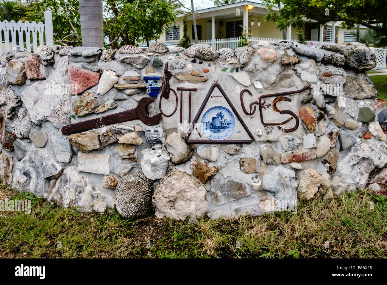 A Wall consisting of stones and sea life items advertising Cottages By the Sea, a resort in St. Croix, U.S. Virgin Islands. Stock Photo