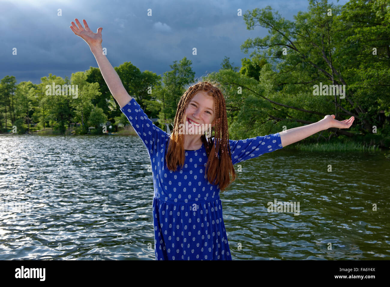 Girl on pier, dark clouds behind, Ellbogensee, Mecklenburg Lake District, Mecklenburg-Western Pomerania, Germany Stock Photo