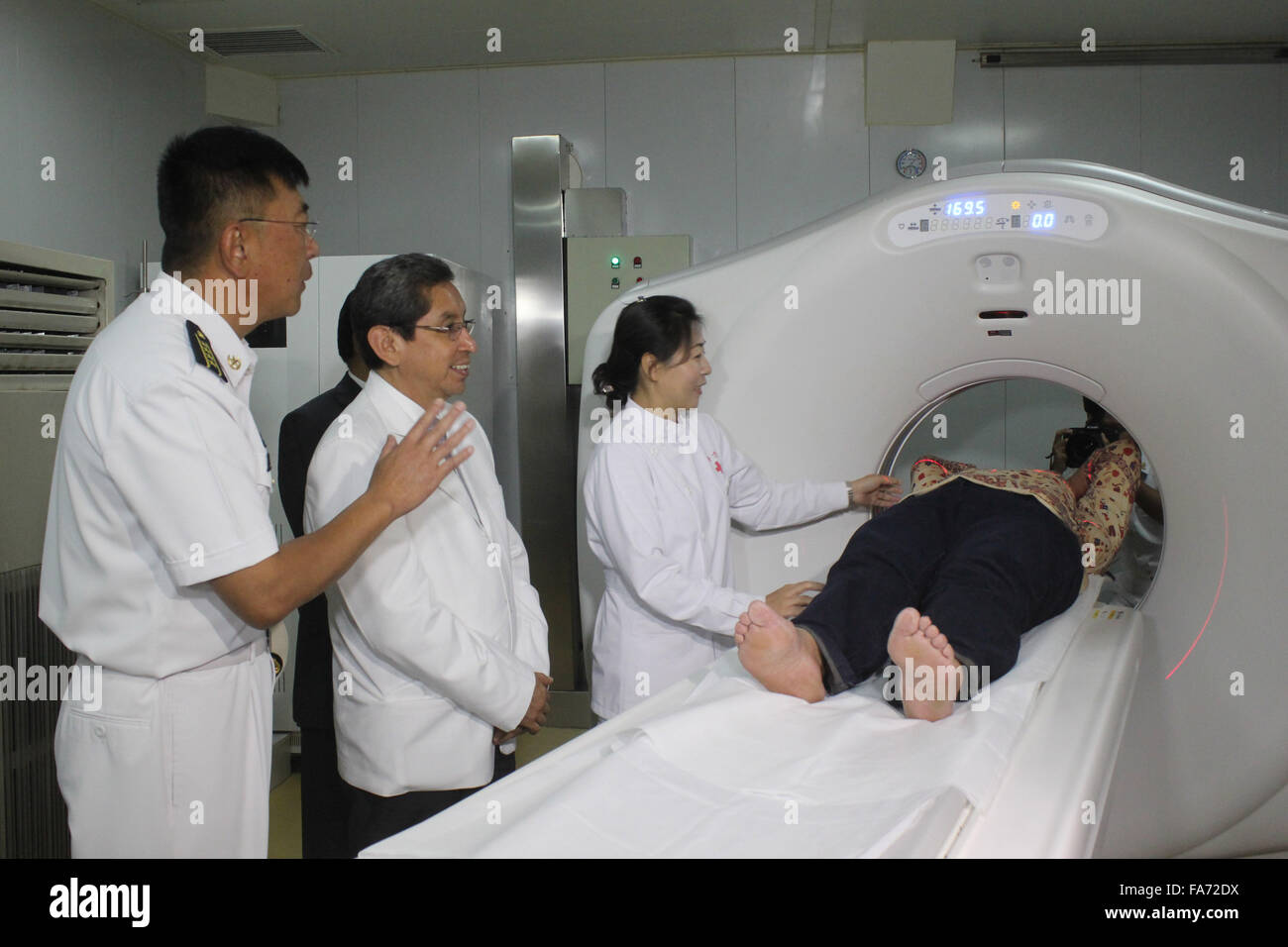Callao, Peru. 22nd Dec, 2015. Peru's Health Minister Anibal Velasquez (2nd L) watches the operation of a tomograph in Chinese naval hospital ship 'Peace Ark' in the port of Callao, Peru, Dec. 22, 2015. China's naval hospital ship Peace Ark arrived in Peru on Sunday for a seven-day medical service and goodwill visit. © Luis Camacho/Xinhua/Alamy Live News Stock Photo