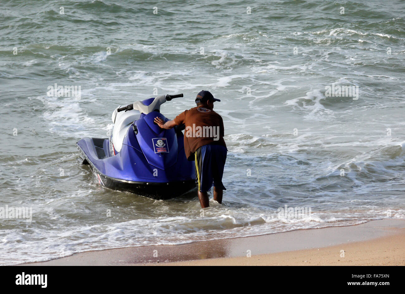 A jetski operative owner with his jetski on Pattaya beach in Thailand Stock Photo