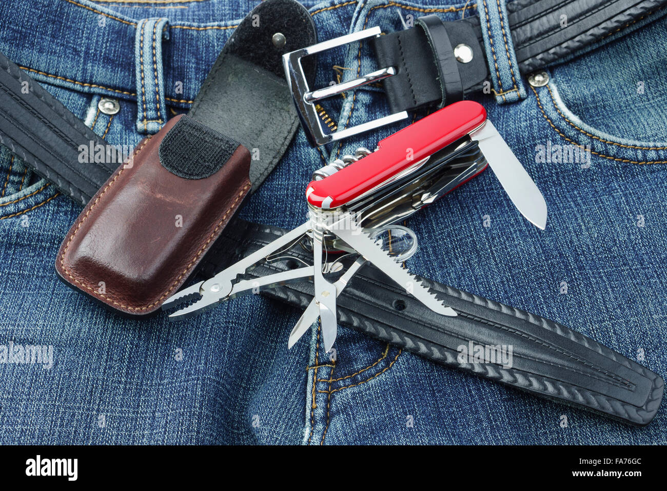 Detail of blue jeans with multifunction penknife and leather case Stock Photo