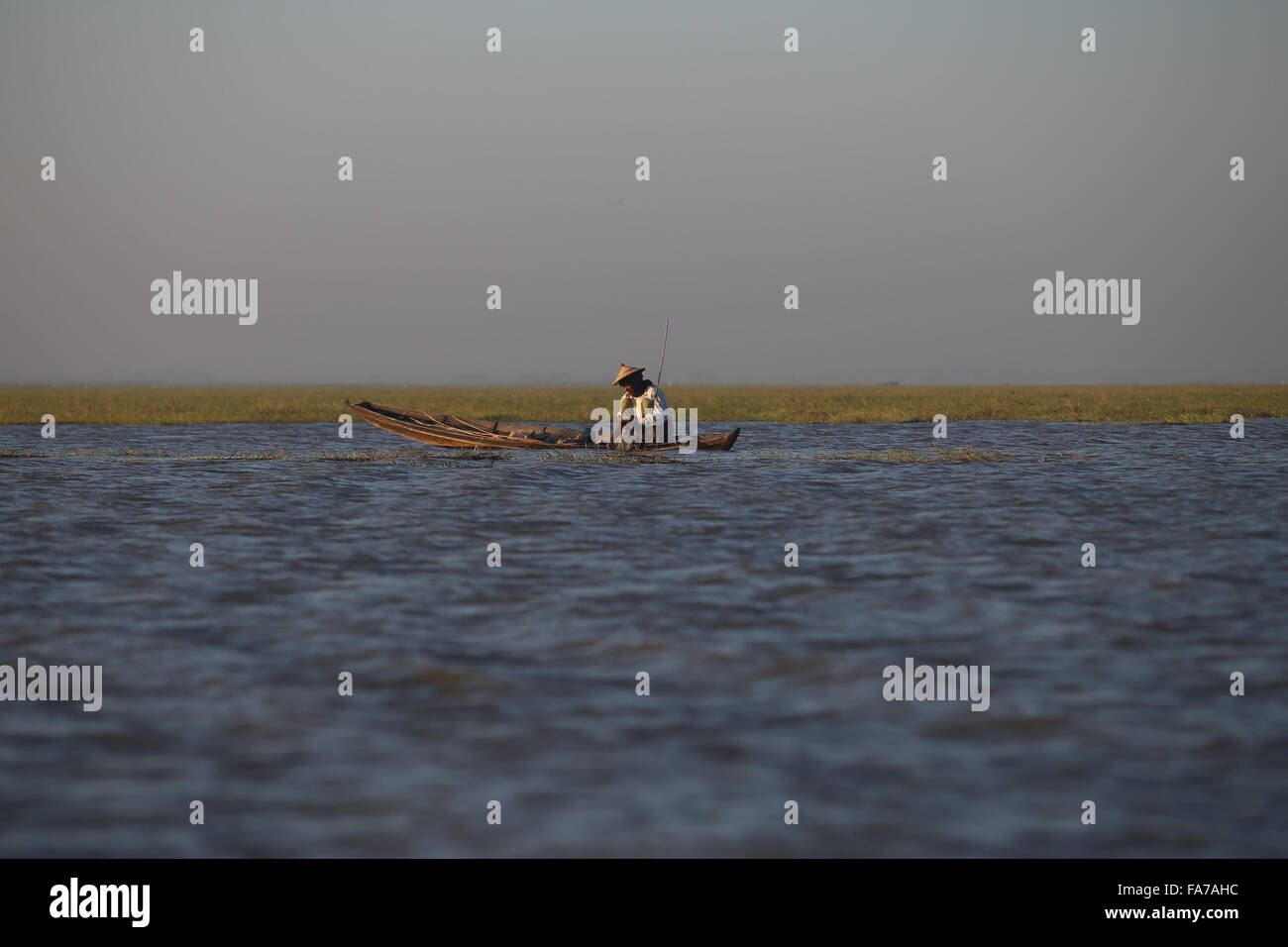 Bago, Myanmar. 23rd Dec, 2015. A fisherman works at Moeyungyi Wetland Wildlife Sanctuary in Bago region, Myanmar, Dec. 23, 2015. Moeyungyi Wetlands is situated in Bago Division. Every year, millions of birds usually fly from the northern hemisphere to the south along the East-Asian Australian Flyway to escape from winter. They stop to rest and feed in Asia. So the flyway contains a network of wetlands and Moeyungyi is one of which could cooperate to certain migrated as well as domestic birds. Credit:  U Aung/Xinhua/Alamy Live News Stock Photo