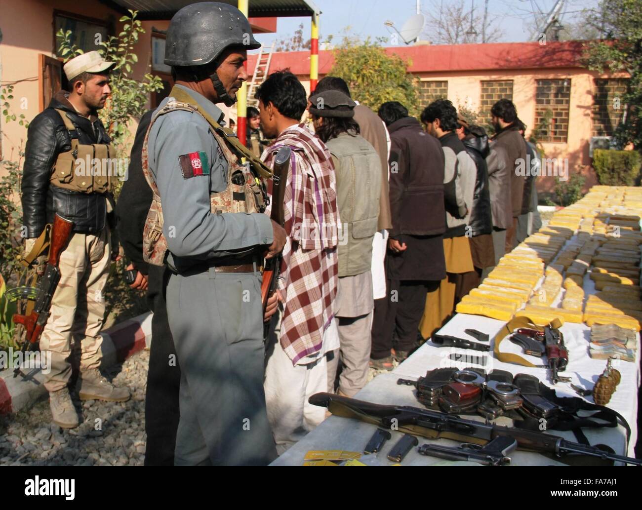 Nangarhar, Afghanistan. 23rd Dec, 2015. Drug smugglers stand handcuffed after being captured during an operation in Nangarhar province, eastern Afghanistan, Dec. 23, 2015. Afghan national police captured 10 drug smugglers with 254kg drugs during an operation in Nangarhar province on Wednesday. Credit:  Rahman Safi/Xinhua/Alamy Live News Stock Photo