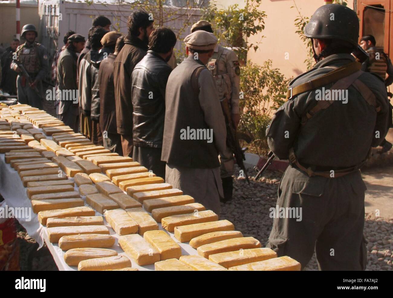 Nangarhar, Afghanistan. 23rd Dec, 2015. Drug smugglers stand handcuffed after being captured during an operation in Nangarhar province, eastern Afghanistan, Dec. 23, 2015. Afghan national police captured 10 drug smugglers with 254kg drugs during an operation in Nangarhar province on Wednesday. Credit:  Rahman Safi/Xinhua/Alamy Live News Stock Photo