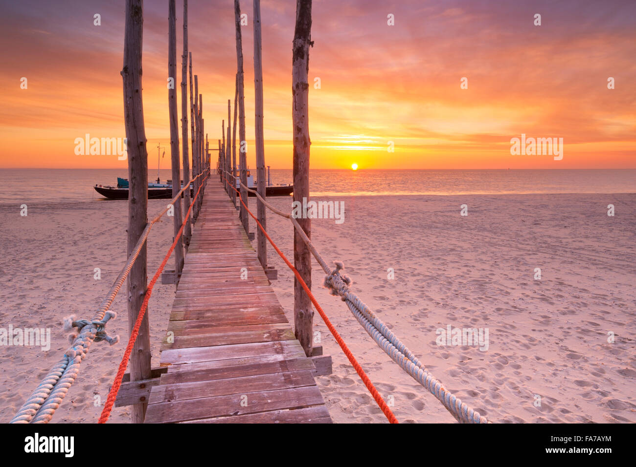 Spectacular sunrise colours over a jetty on a beach on the island of Texel in The Netherlands. Stock Photo