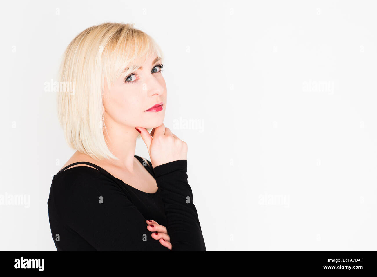 Decision making - difficult life choices and options : A young slim blonde blond haired woman girl, thinking, pondering, thoughtful,  UK Stock Photo