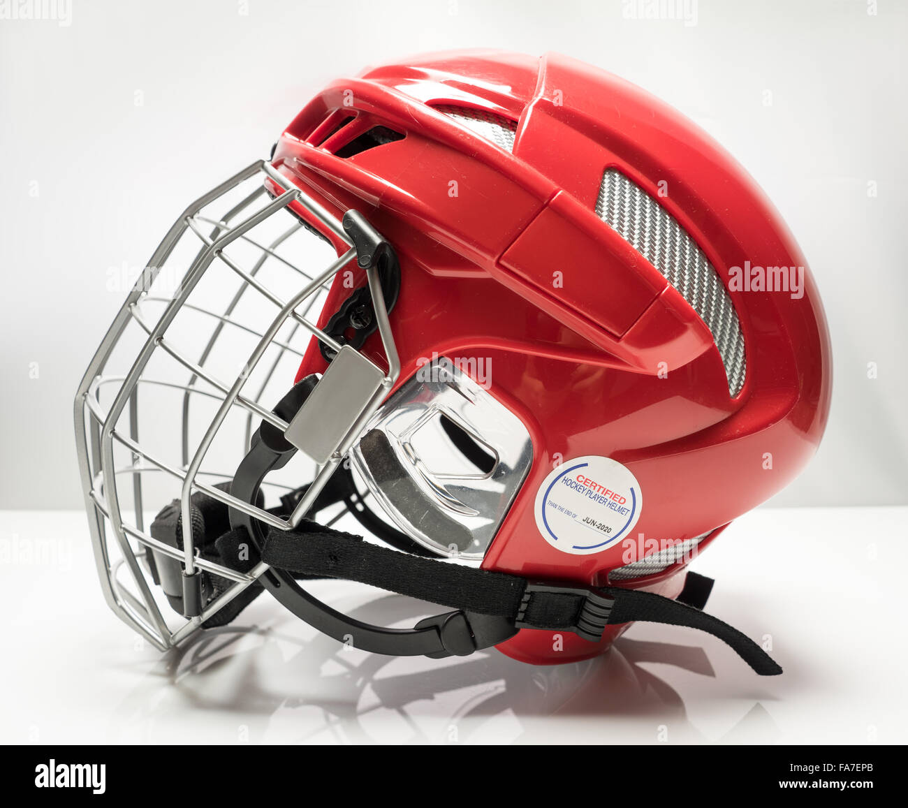 Red hockey helmet with cage on light background Stock Photo Alamy