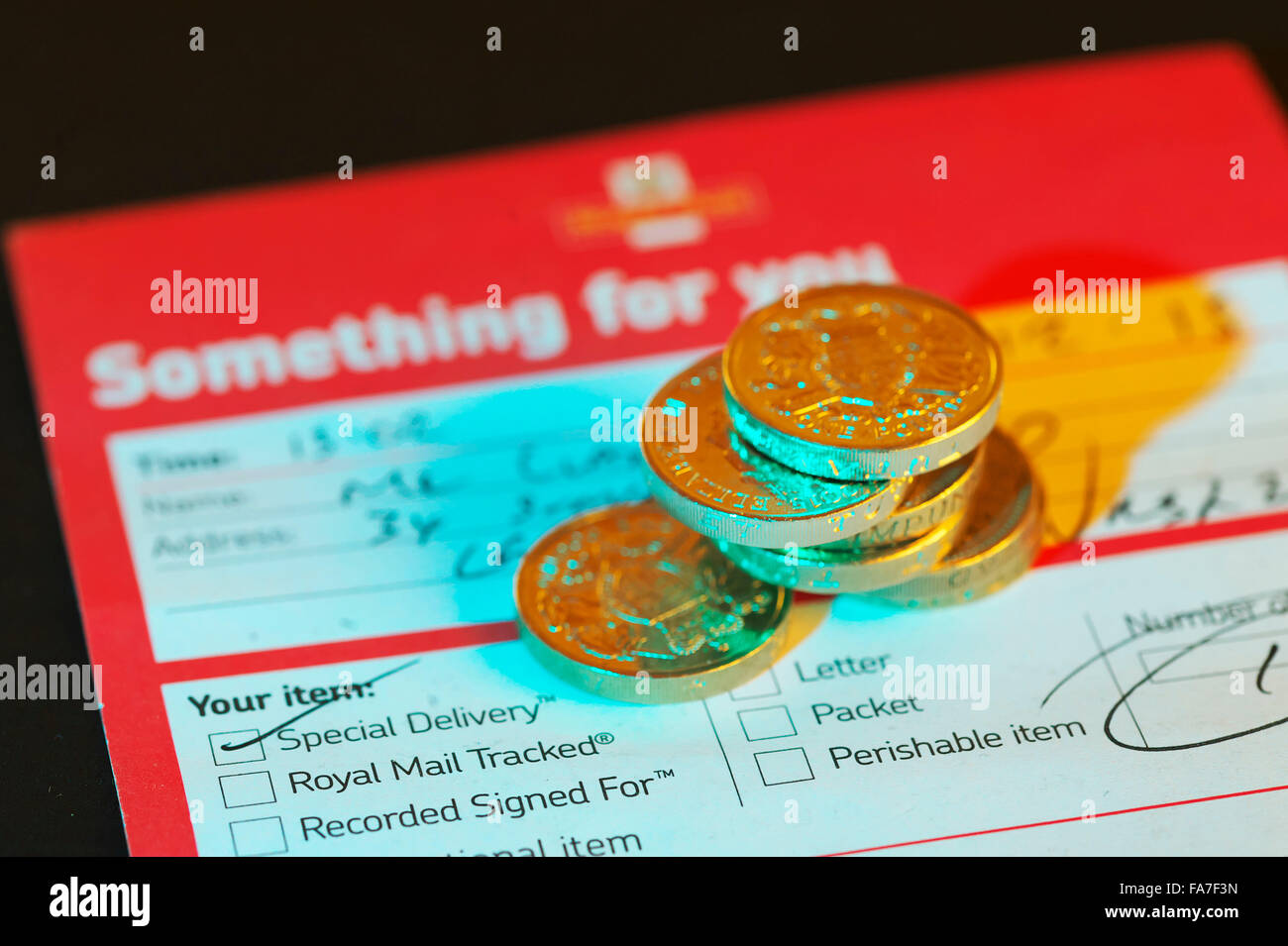 Missed delivery postage note from the UK Royal Mail with money in shot Stock Photo