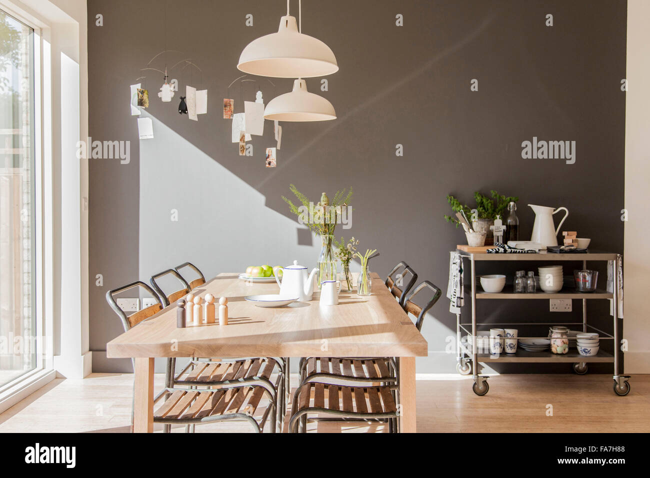 kitchen and dining area table and chairs with pendant lighting in residential house, Cambridge A house combining modern minimalist style with display of traditional objects used in every day life. Stock Photo