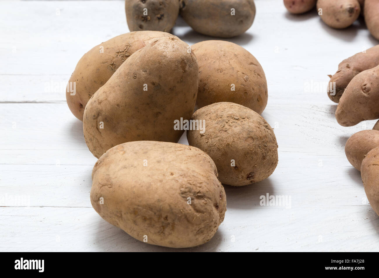 Potatoes on white wooden board Concept. Stock Photo