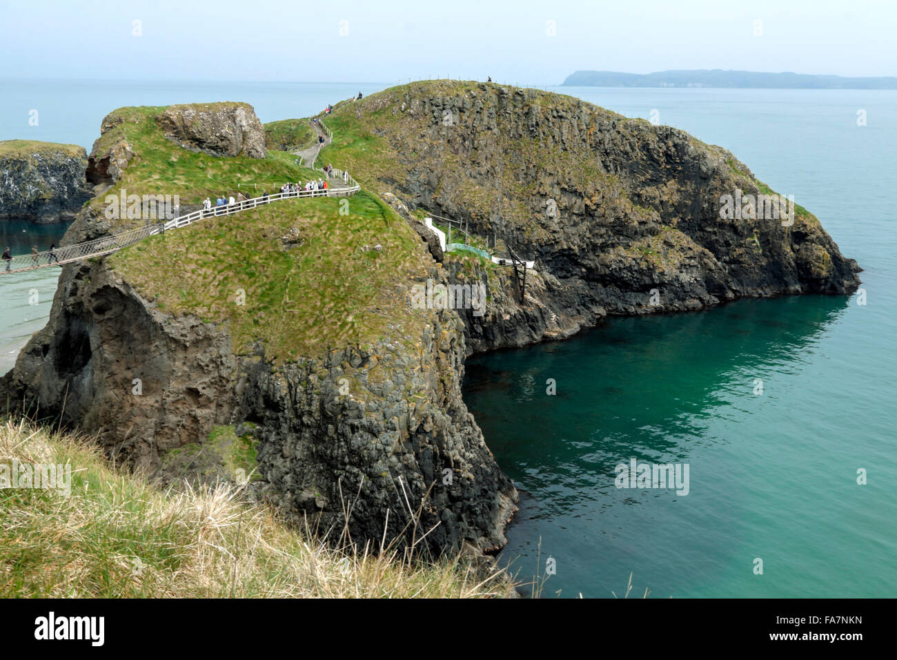 Tourists cross the Carrick a Rede Rope Bridge to Carrick island, Ballycastle, County Antrim, Northern Ireland, United Kingdom. Stock Photo