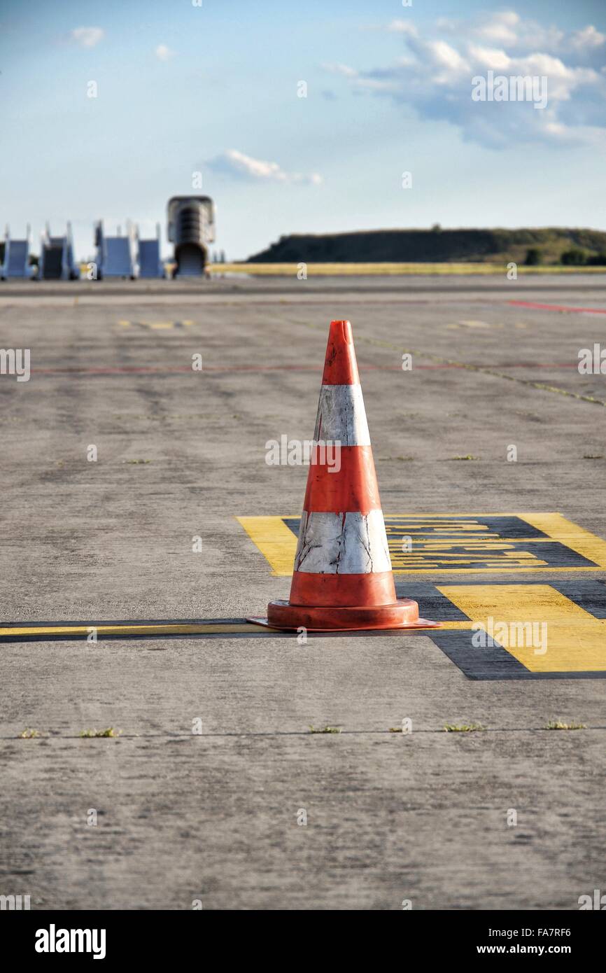 Orange traffic cone stand on airport runway in sunny day Stock