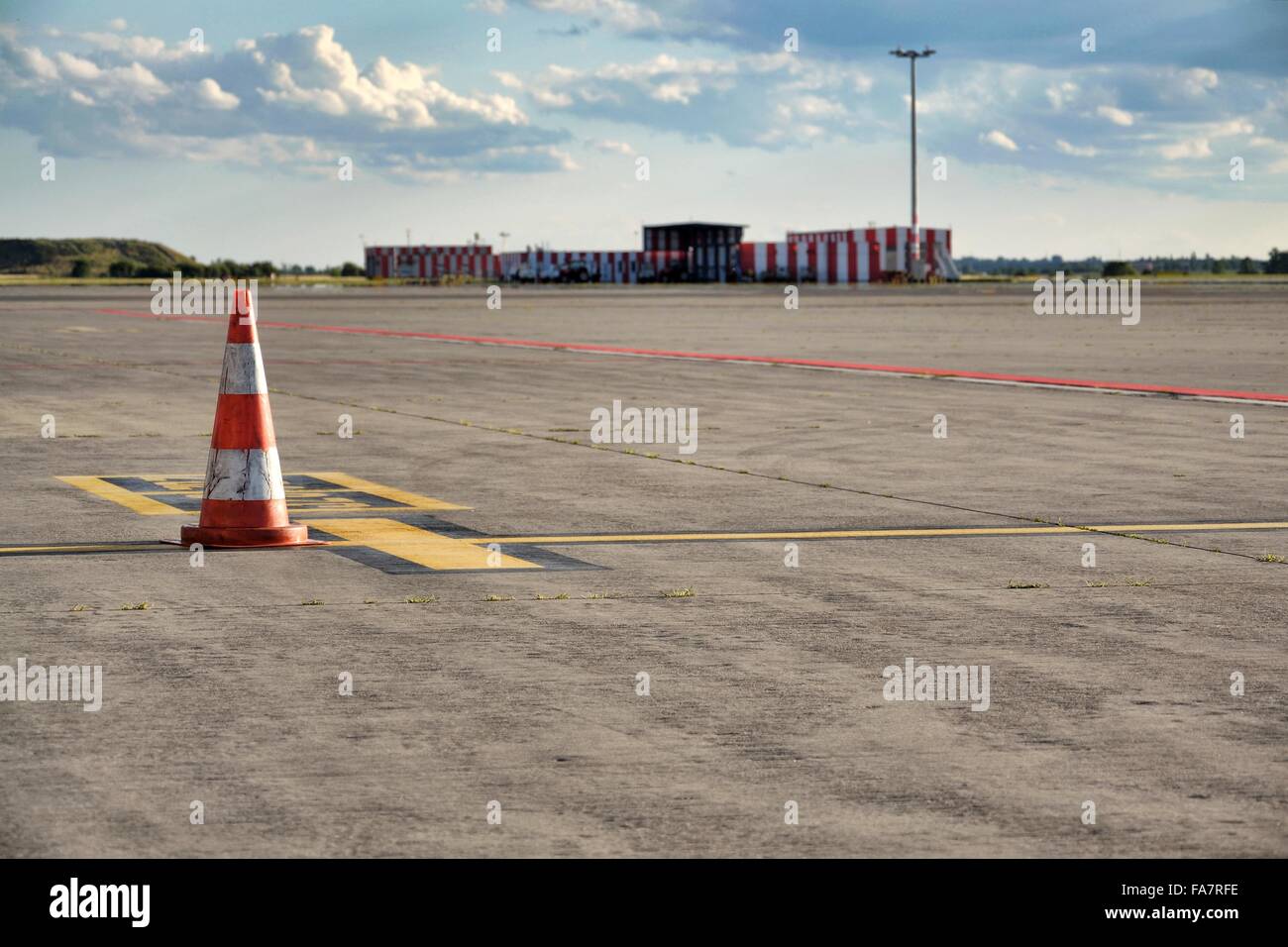 Orange Traffic Cone Stand On Airport Runway In Sunny Day Stock Photo orange-traffic-cone-stand-on-airport-runway-in-sunny-day-stock-photo