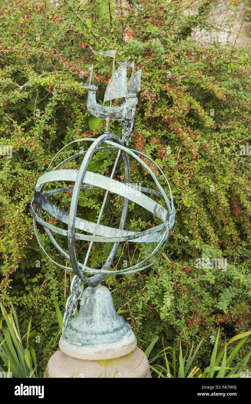 Armillary sphere with berberis behind at Tintinhull Garden, Tintinhull, Somerset. Stock Photo