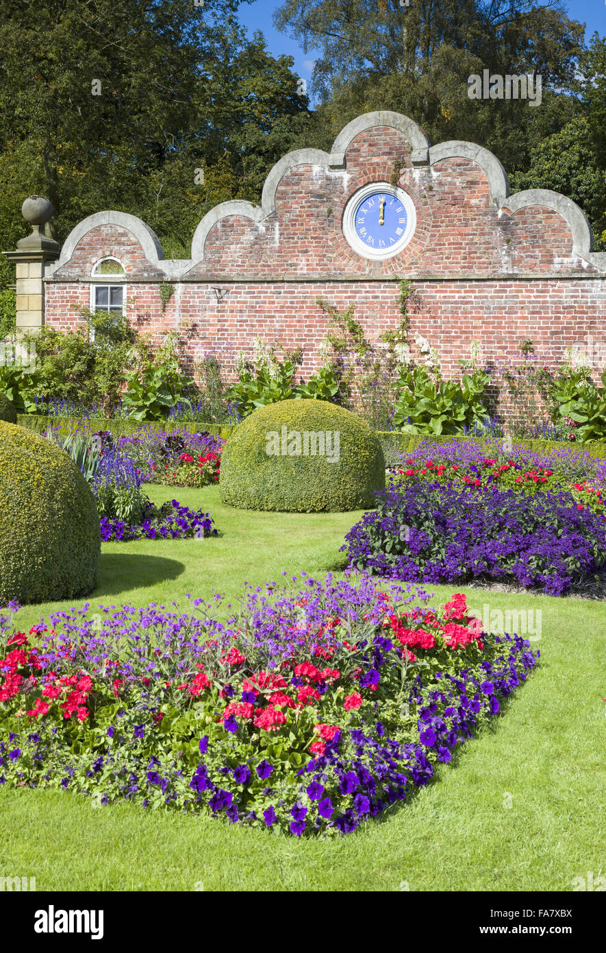 The Victorian parterre at Erddig Hall.  Bedding plants include pelargoniums, verbena and petunias.  The clock was brought from Stansty Park and added to the wall in about 1912. Photographed September Stock Photo
