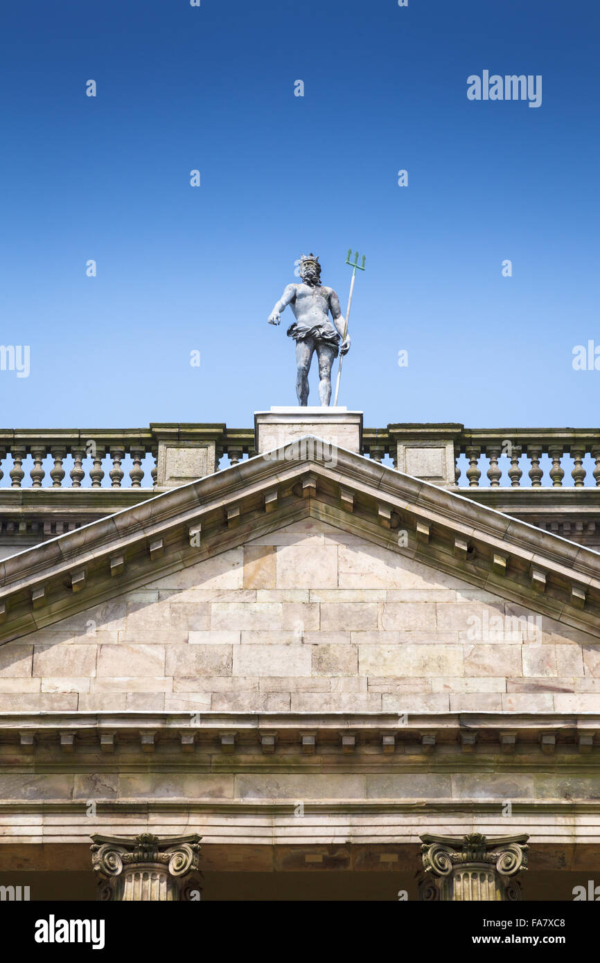 A statue of Neptune, trident in hand, stands on the roof of the south front of Lyme Park, Disley, Cheshire. Photographed in July. Stock Photo