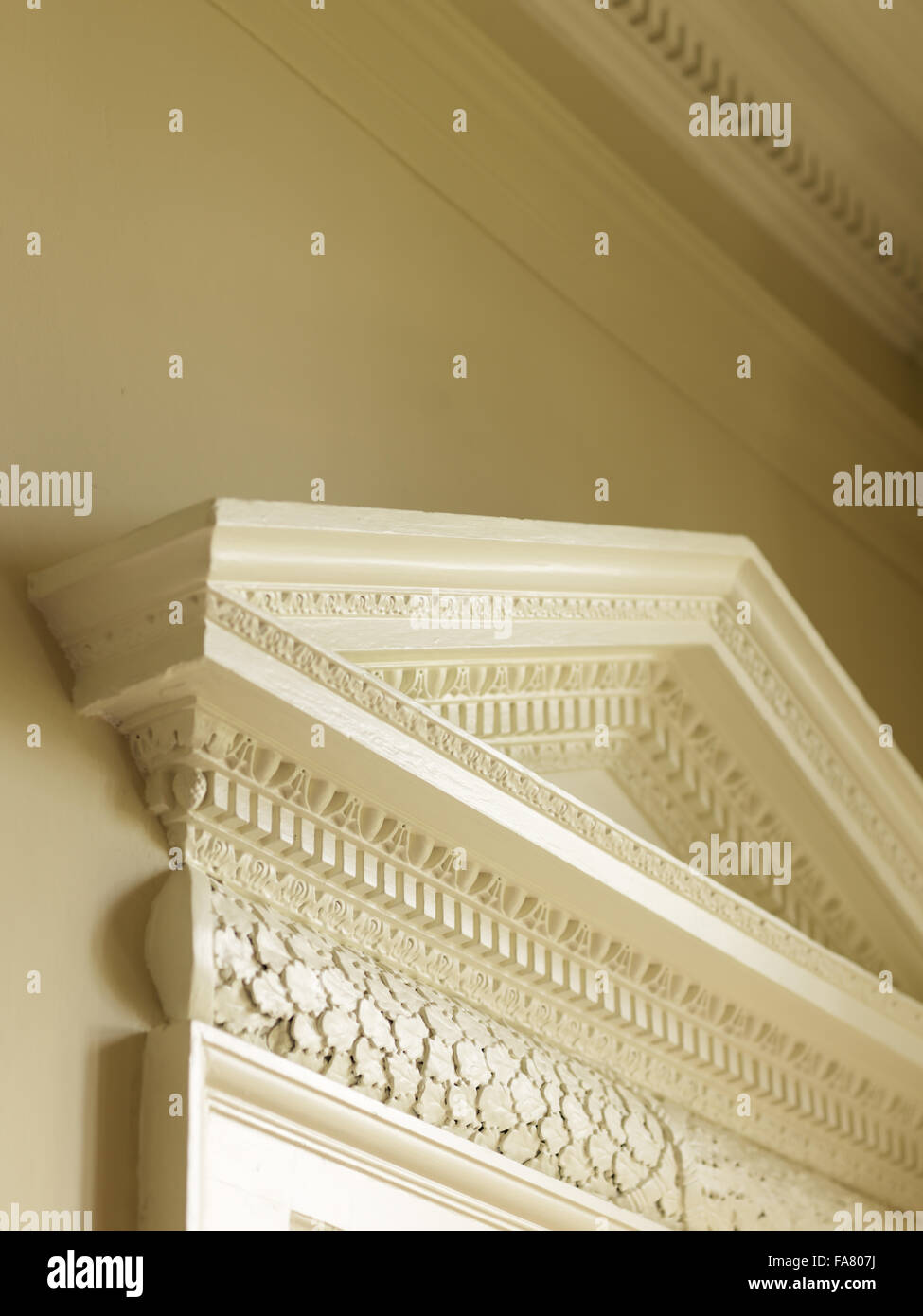 Detail of the pediment and mouldings above a door in the Palladian Dining Room, Avebury Manor, Wiltshire, in April 2011, before its redecoration. This view was taken prior to the BBC filming the transformation of the house, while the rooms were being clea Stock Photo