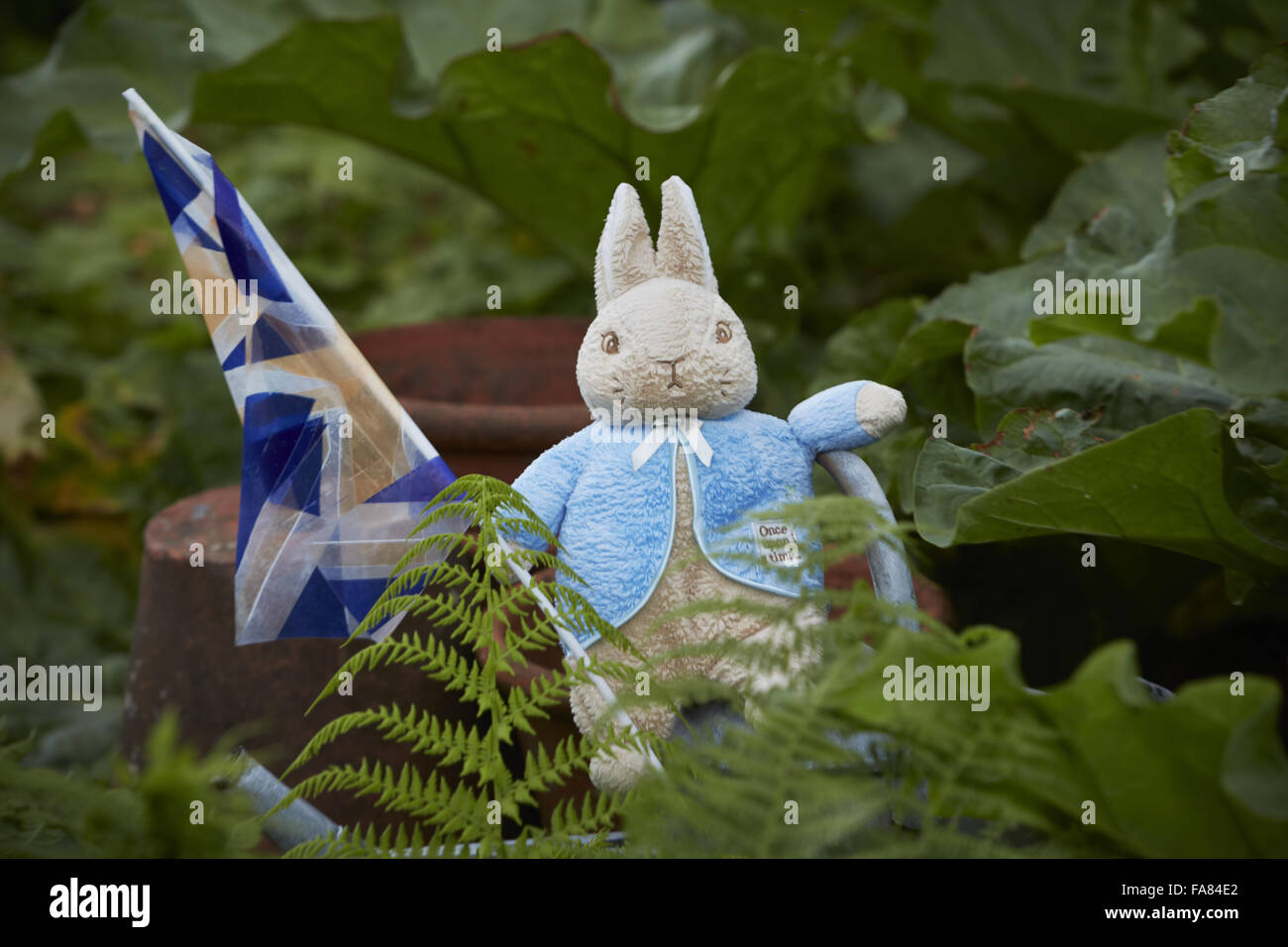 Peter Rabbit toy in the garden at Hill Top, near Sawrey, Cumbria. The house was owned by Beatrix Potter from 1905 until her death in 1943. Photograph shows objects that may be trademarked Stock Photo