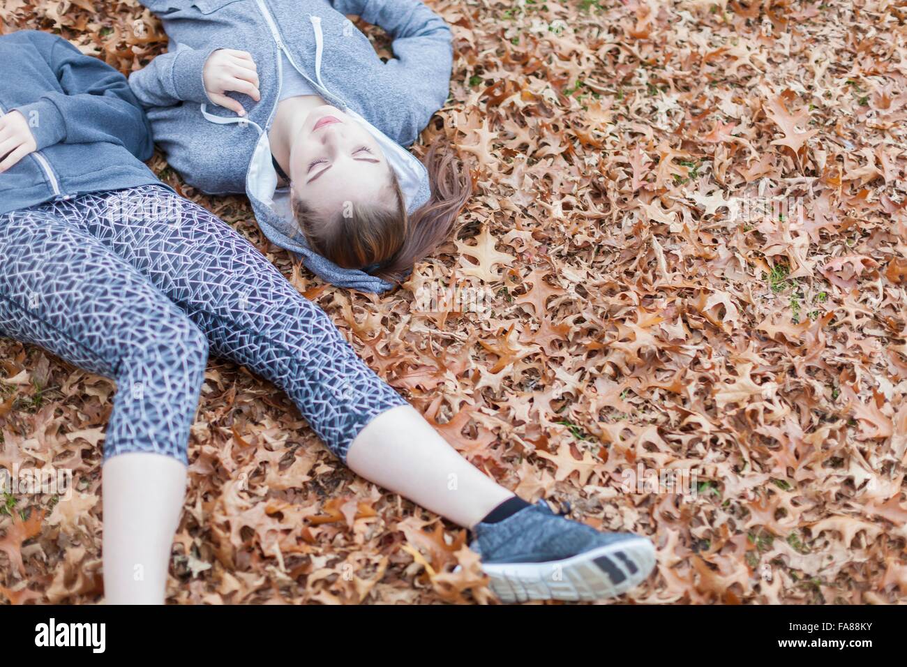 High angle view of young women lying on autumn leaves Stock Photo - Alamy