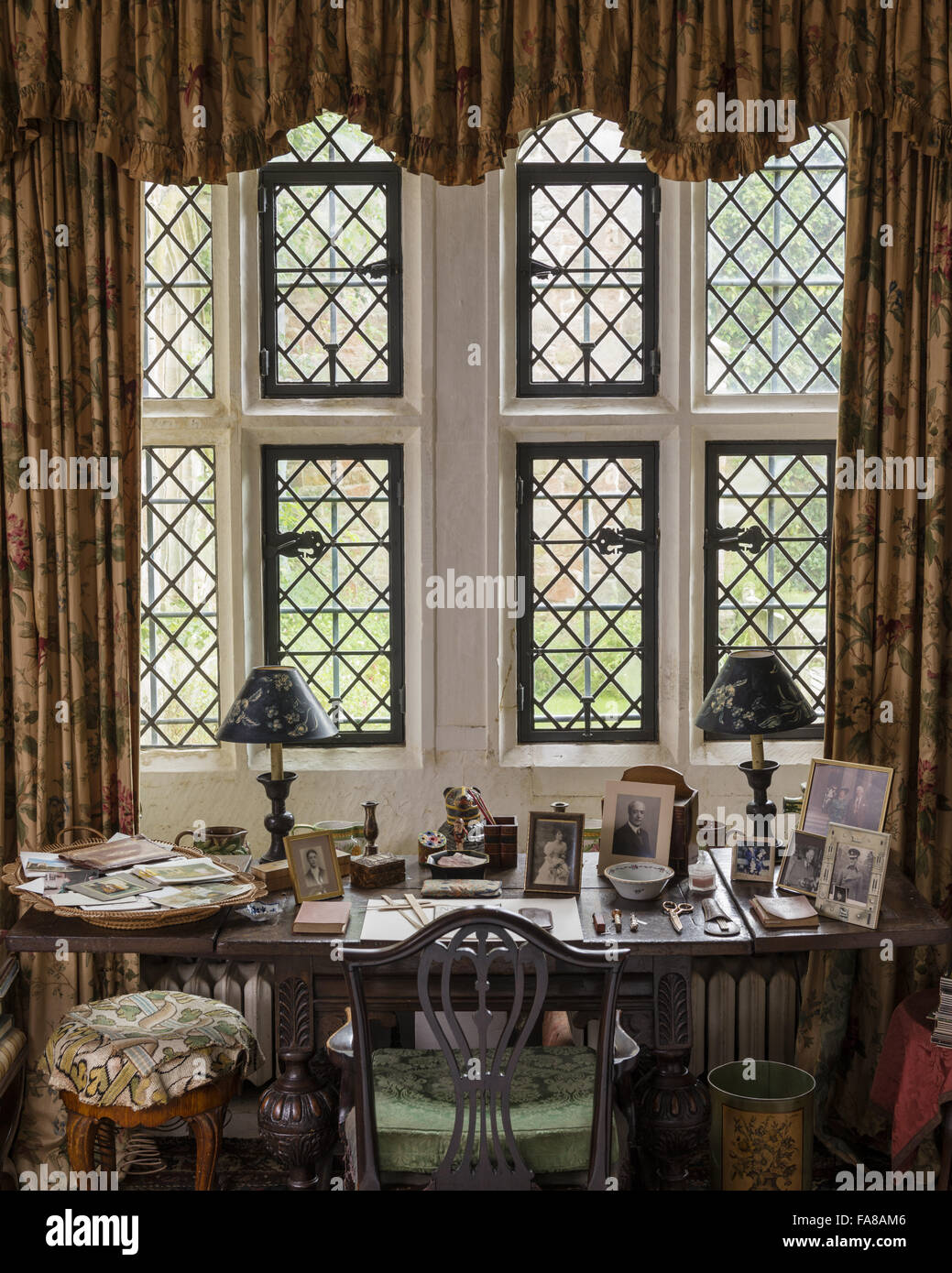 Anne Messel's desk beneath the window in The Library, Nymans, West Sussex. Anne, later Lady Rosse, was the the granddaughter of Ludwig Messel, who bought the Nymans Estate in the 1890s, extending the house and founding its stunning gardens. Stock Photo