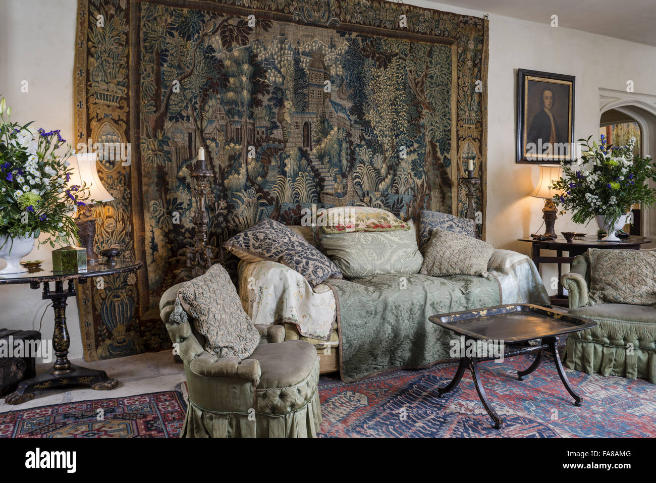 View of the sofa, chairs and wall tapestry in the Garden Hall, Nymans, West Sussex. Stock Photo