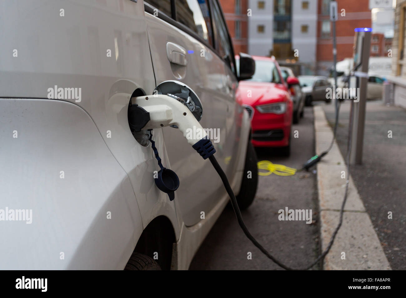 White electric car charging in the streets of Oslo, Norway Stock Photo