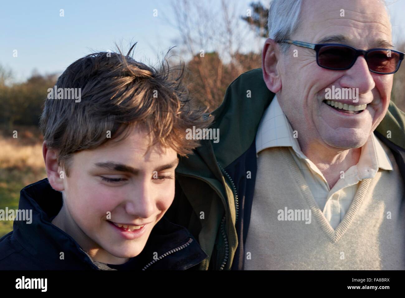 Grandfather and grandson walking through field Stock Photo
