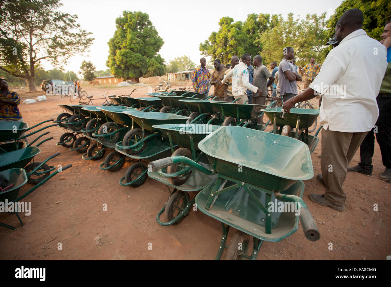 Small farmers receive wheel barrows at a distribution in Banfora Department, Burkina Faso. Stock Photo