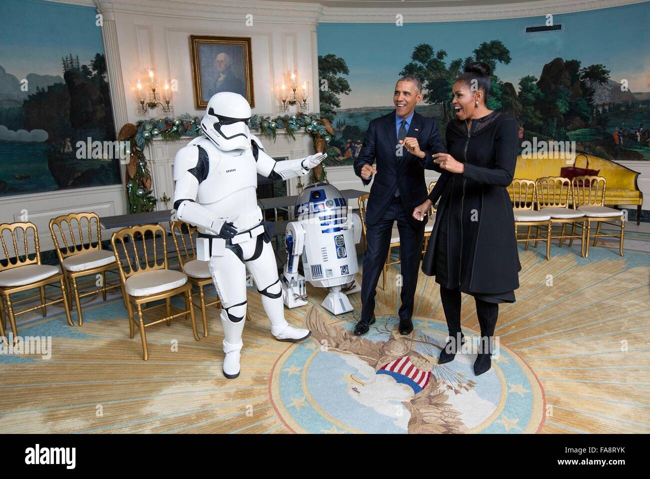 U.S. President Barack Obama and First Lady Michelle Obama meet with an Imperial Storm Trooper and R2D2, characters from the Star Wars movies at the White House December 18, 2015 in Washington, DC. The characters were there for a screening of Star Wars: The Force Awakens at the White House Family Theater, where President Obama and the First Lady were hosting Gold Star families. Stock Photo