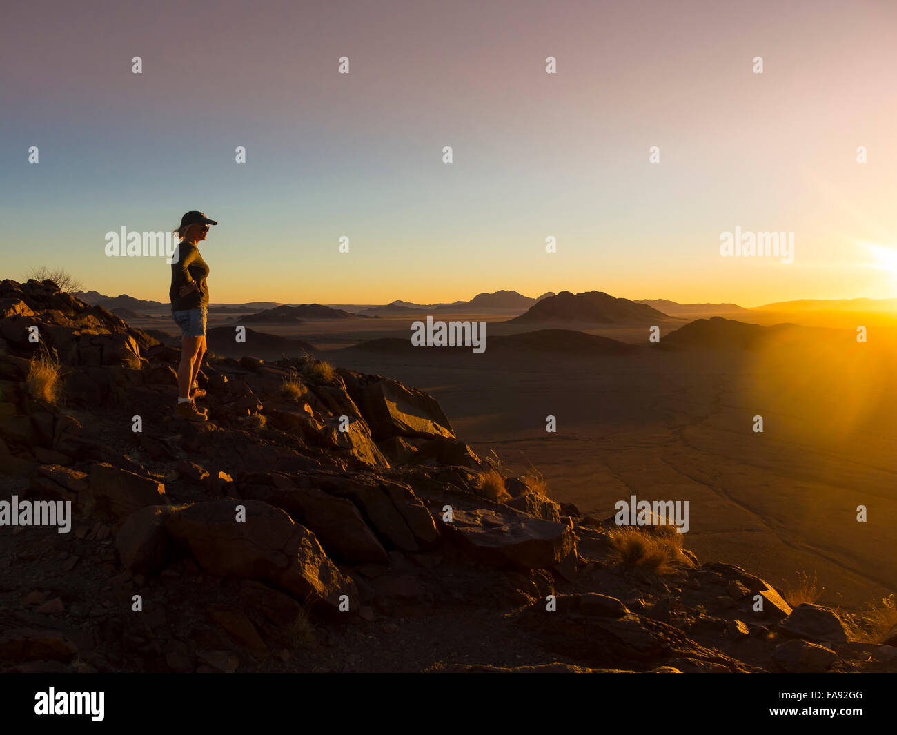 Woman at sunset overlooking Tsaris Mountains, Hardap Region, Namibia Stock Photo