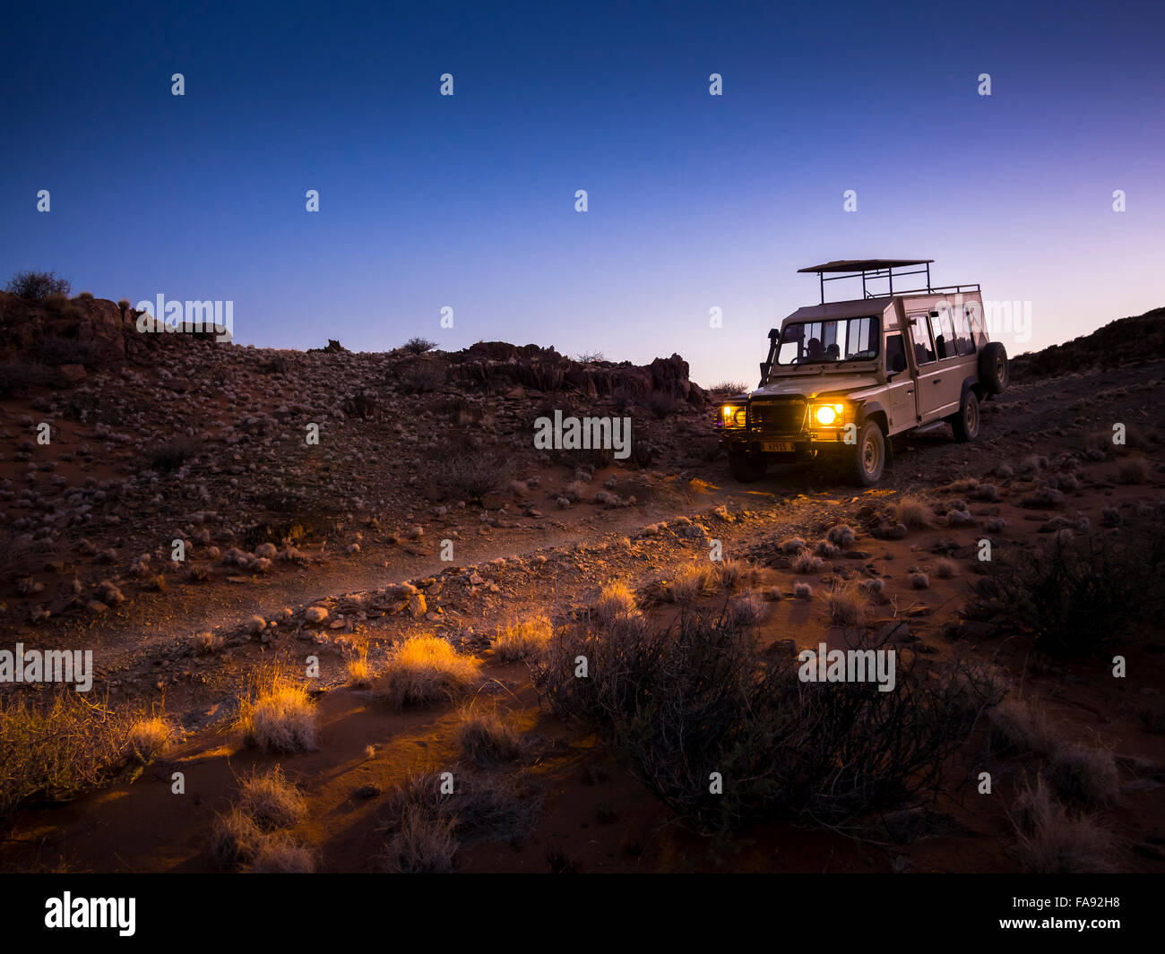 Land Rover driving in the Kulala Wilderness Reserve, Namib Desert at dawn, Tsaris Mountains, Hardap Region, Namibia Stock Photo