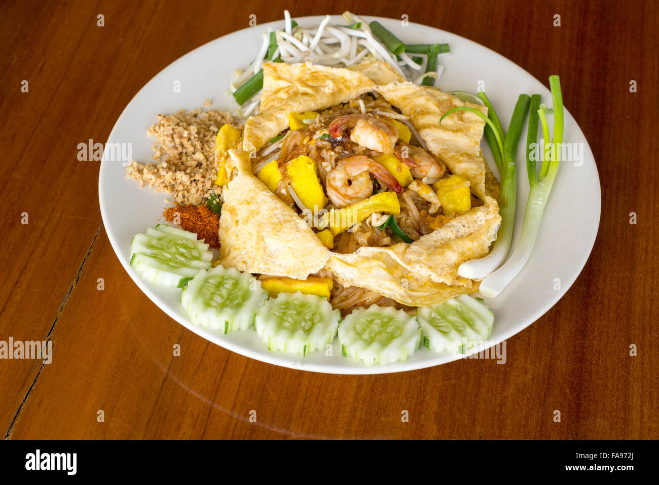 Thin rice noodles fried Thai style with prawns, tofu, vegetable, egg and peanuts, one of Thailand's national main dish Stock Photo