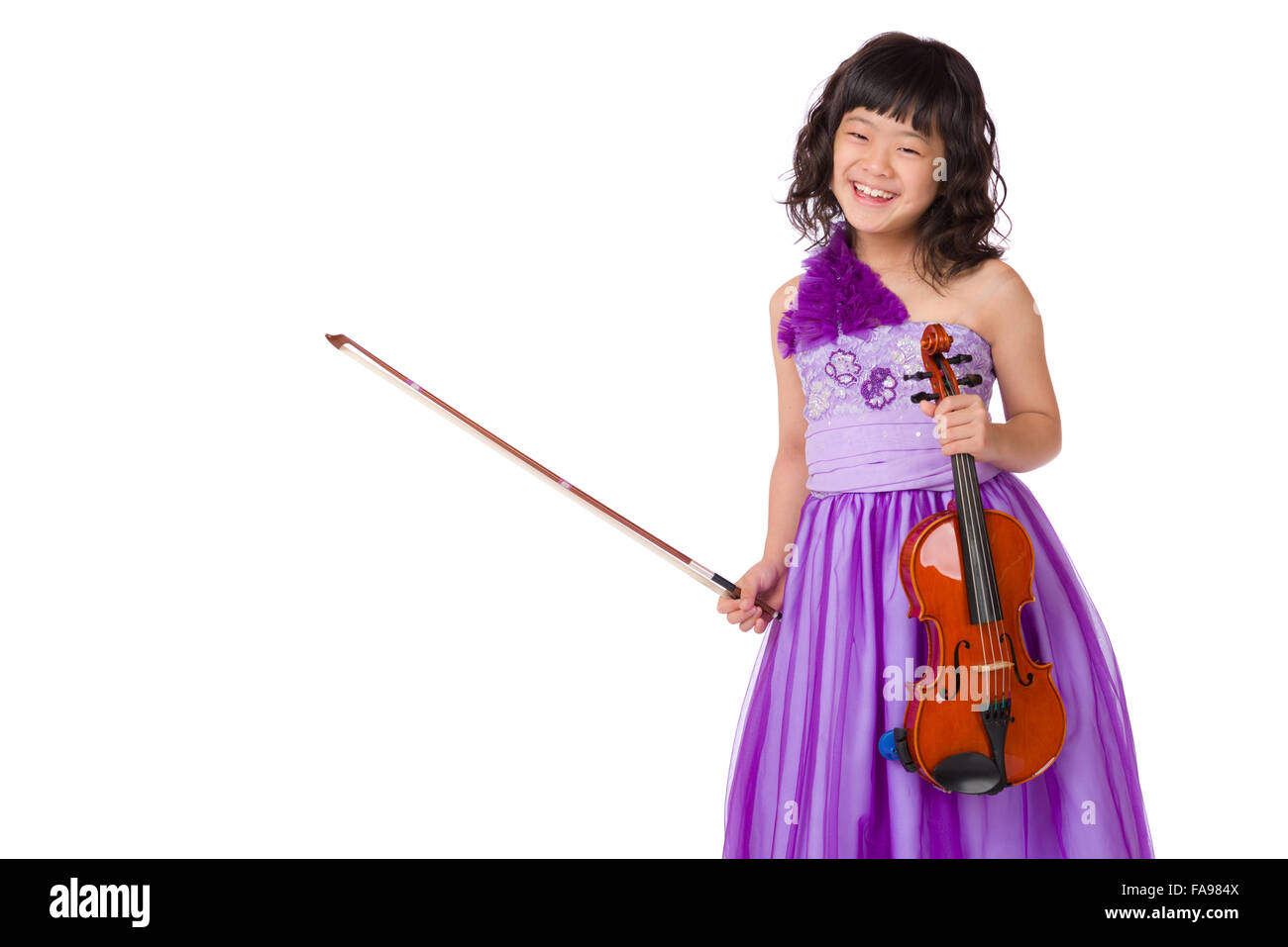A portrait of a cute, happy and young Japanese girl in a purple dress on a white background with a violin. Stock Photo