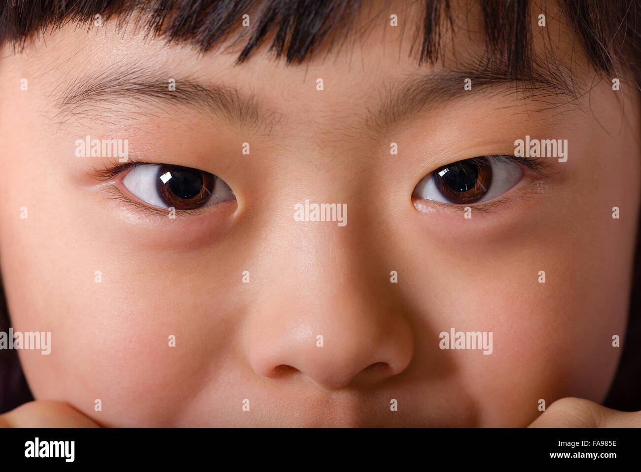 A close up macro shot of a young Japanese girl's face. Stock Photo