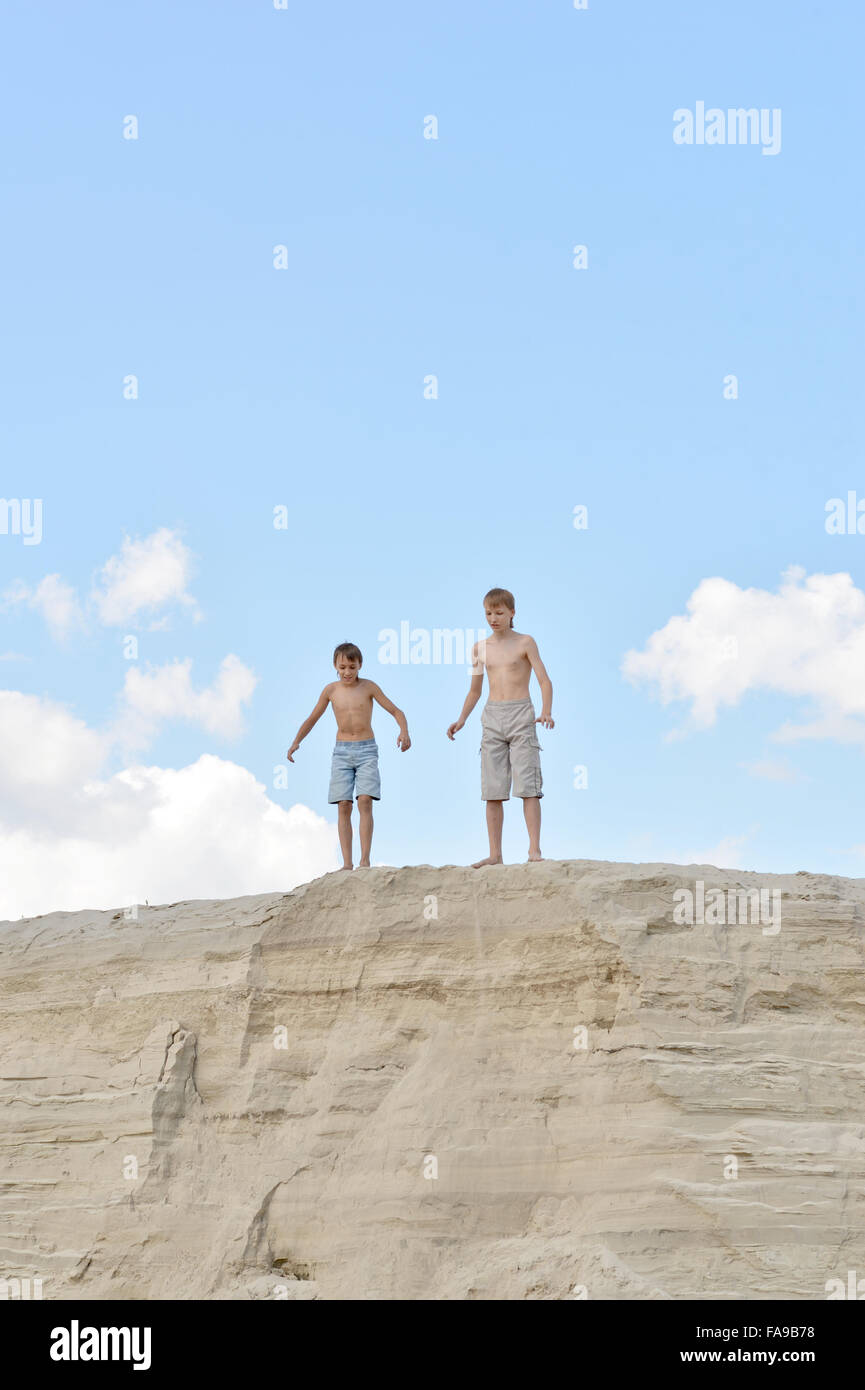 Two boys on a sandy hill Stock Photo - Alamy