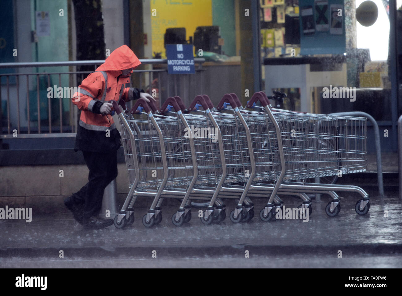 Bristol, UK. 24th Dec, 2015. UK Weather. Collecting supermarkets trolleys in Heavy Rain in Bristol, Whiteladies Road.Storm Eva batters the coast bringing more rain and wind to the UK. Credit:  Robert Timoney/Alamy Live News Stock Photo