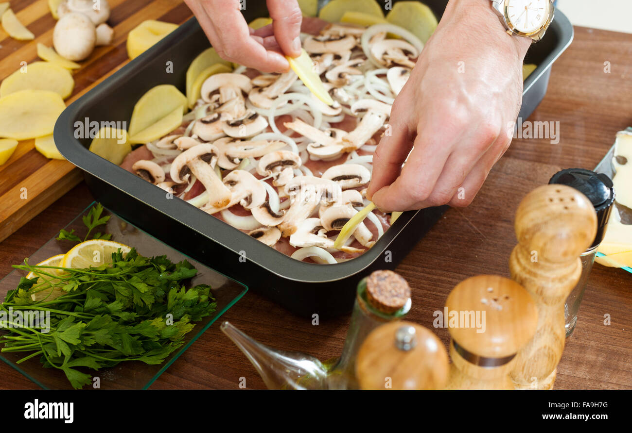 Stages of cooking frenchstyle meat. Putting portatoes in roasting pan