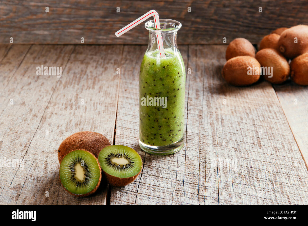 bottle of kiwi juice with fresh fruits on wooden table Stock Photo