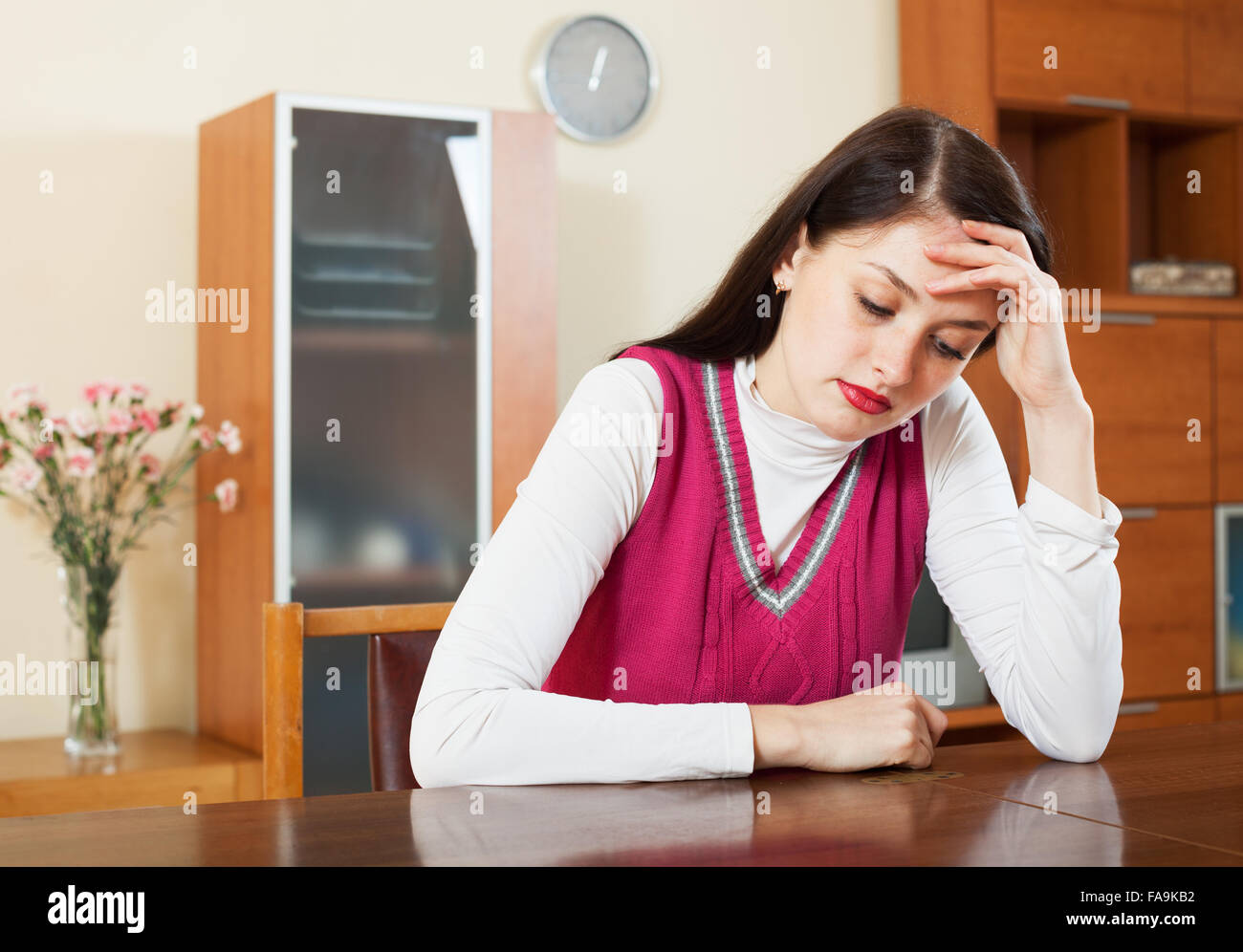 Crying lonely brunette woman at table in home Stock Photo - Alamy