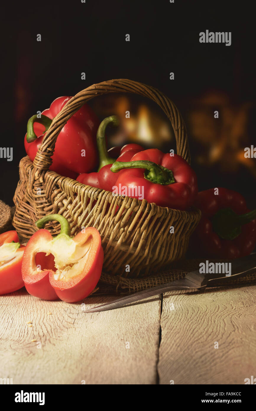 red Paprika in a Basket before a Fireplace Stock Photo