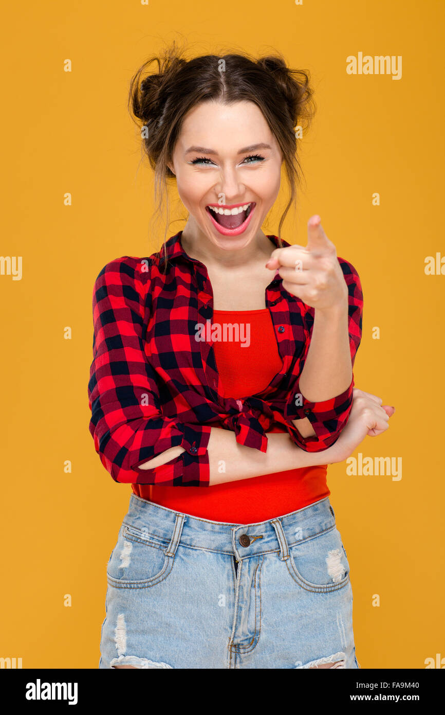 Happy cheerful young woman in plaid shirt laughing and pointing on you ...