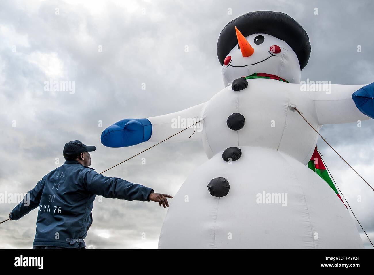 A U.S. Navy sailor erects an inflatable snowman on the flight deck of the aircraft carrier USS Ronald Reagan to celebrate Christmas during a port visit December 17, 2015 in Yokosuka, Japan. Stock Photo